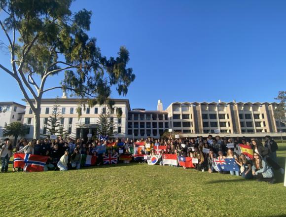 Large group of EAP students holding flags outdoor